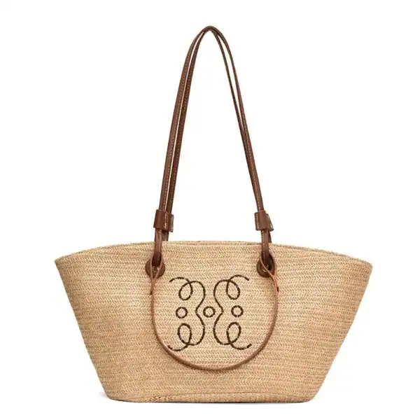 Beige stråkorg med bruna handtag och dekorativt mönster.
