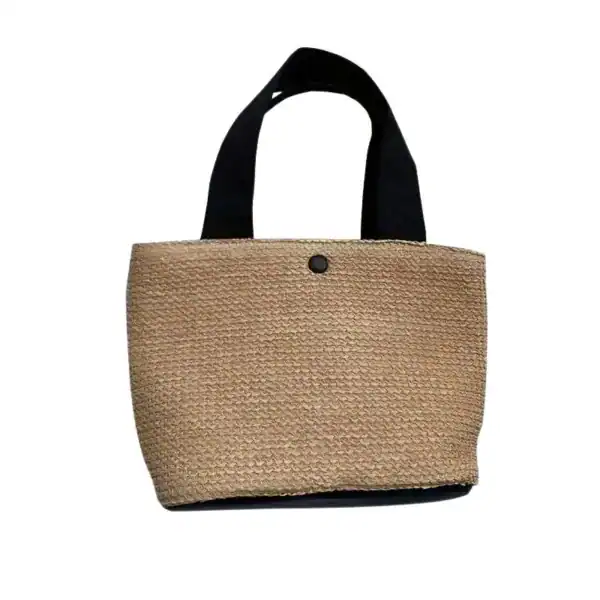 Beige stråväska med svarta handtag och enkla detaljer.
