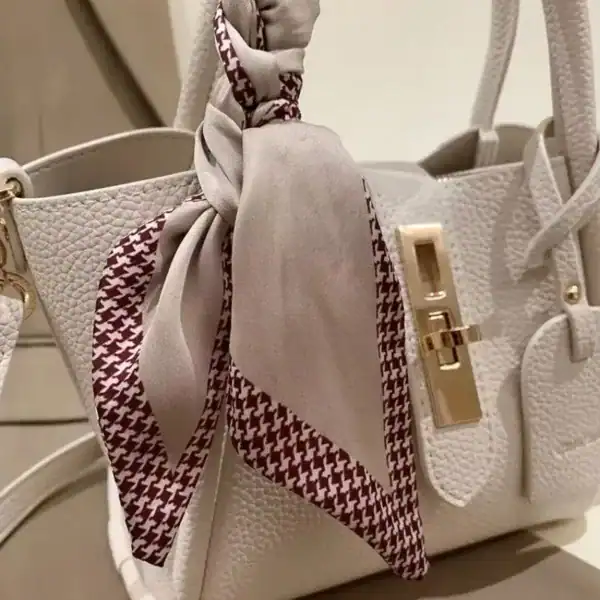 Beige handväska med hundtäckad siden-scarf och guldlock.