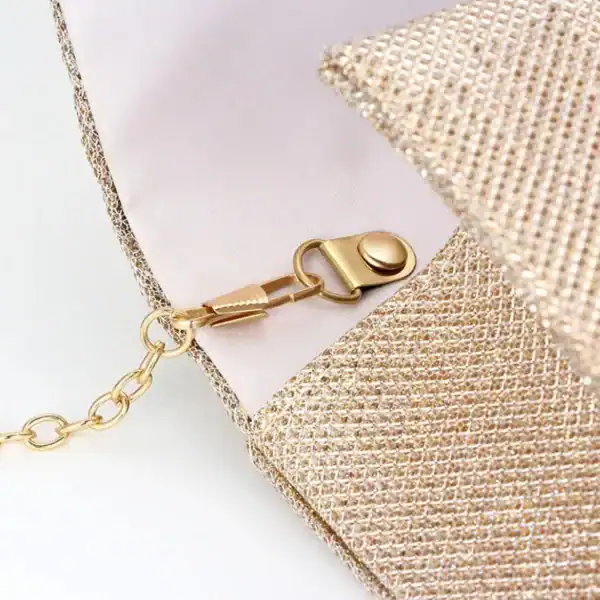 Beige vävd clutch med guld fäste och kedja.