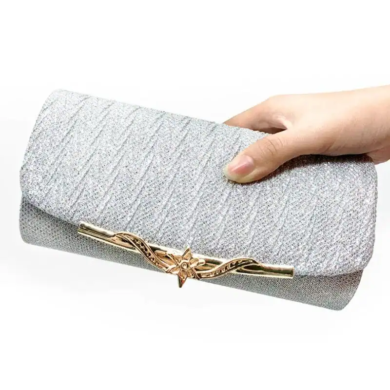 Beige vävd clutch med guldaktig blomma på snörning.