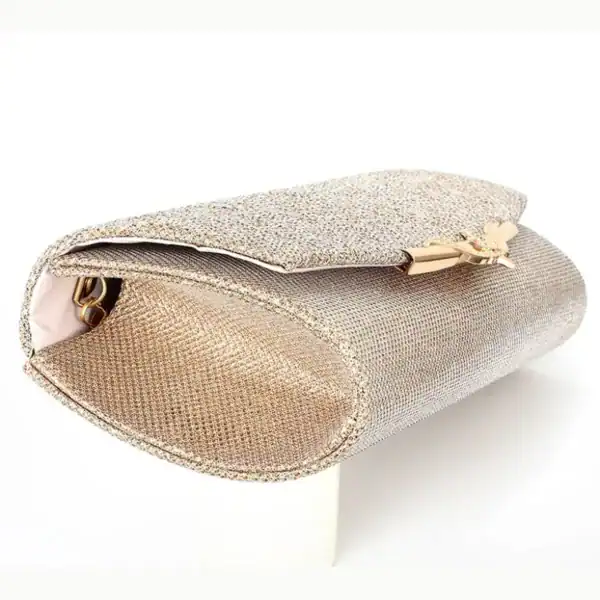 Beige vävd clutch med guldaccent och öppen topp.