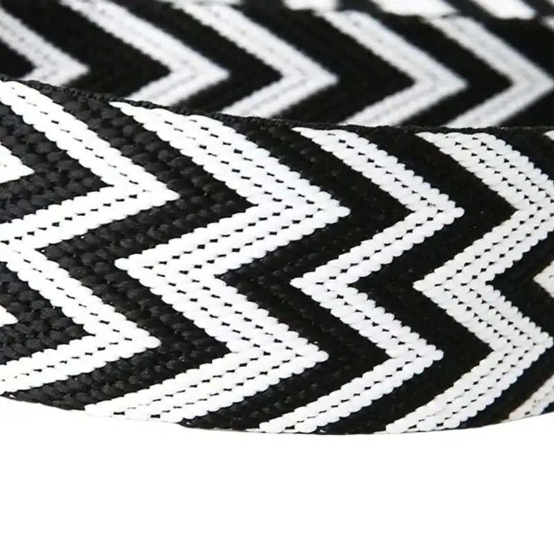 Blå bröstväska med svart-vit zigzag-mönster, detalj på textilband.