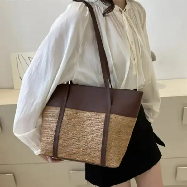 Brun beige flätad shoppingväska med läderdetaljer och axelrem.