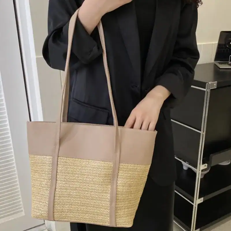 Brun beige flätad shoppingväska med läderdetaljer och handtag.