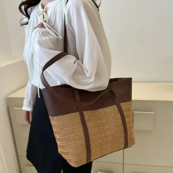 Brun beige flätad shoppingväska med läderdetaljer och axelrem.