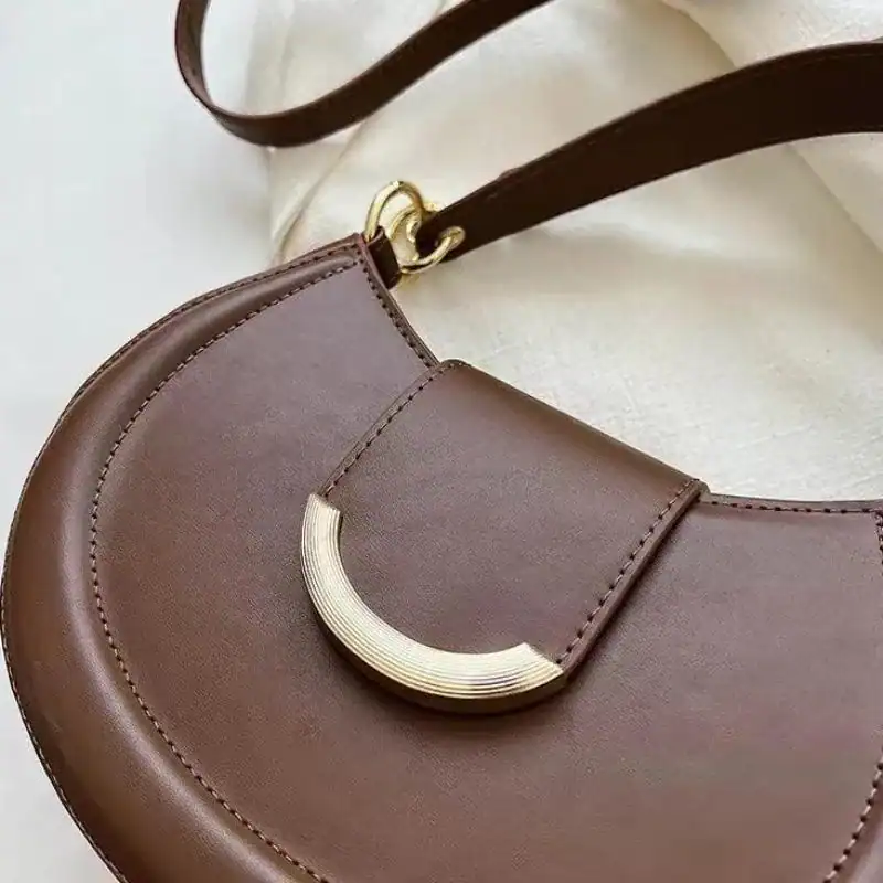 Brun halvmånsväska med lås, elegant läderhandväska med guldpläterad detalj.