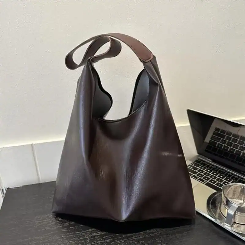 Brun hoboväska i läder, stilren axelväska med enkel handtag, perfekt för vardag och arbete.