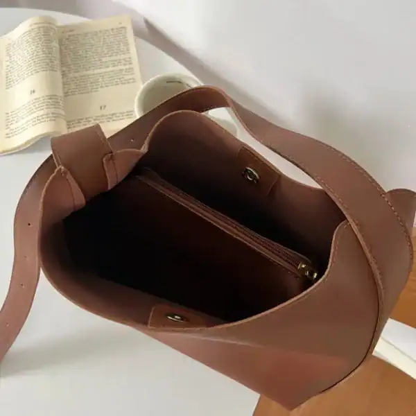 Brun Axelväska med necessär, inre plånboksfack och elegant design.