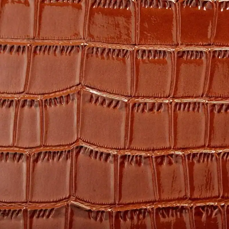 Brun krokodilmönstrad väskset fyra delar, detalj på textur och färg.