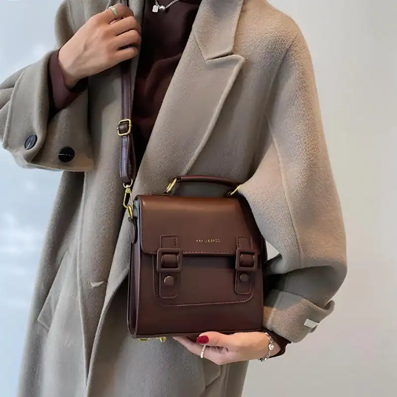 Brun liten portföljväska med axelrem, läder, elegant design för kvinnor.