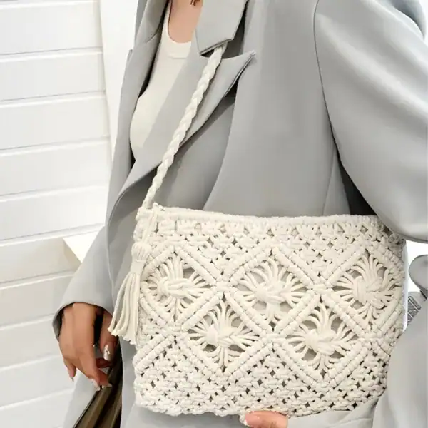 Brun makramé clutch med tassar och broderad detalj.
