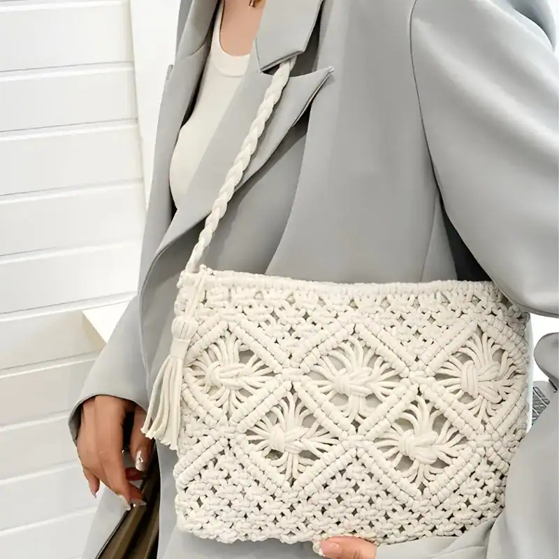 Brun makramé clutch med tassar och broderad detalj.