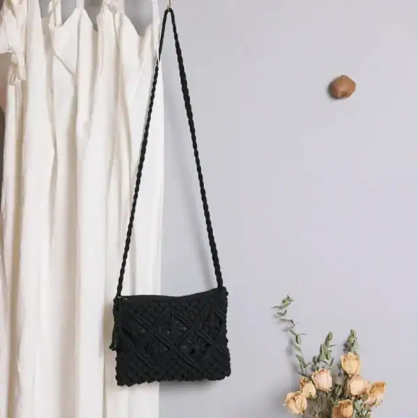 Brun makramé clutch med lös bälte, hängande mot vit gardin och blommor.