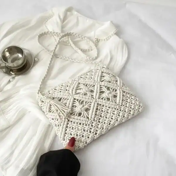 Brun makramé clutch med tasslar och silverfärgad axelrem.