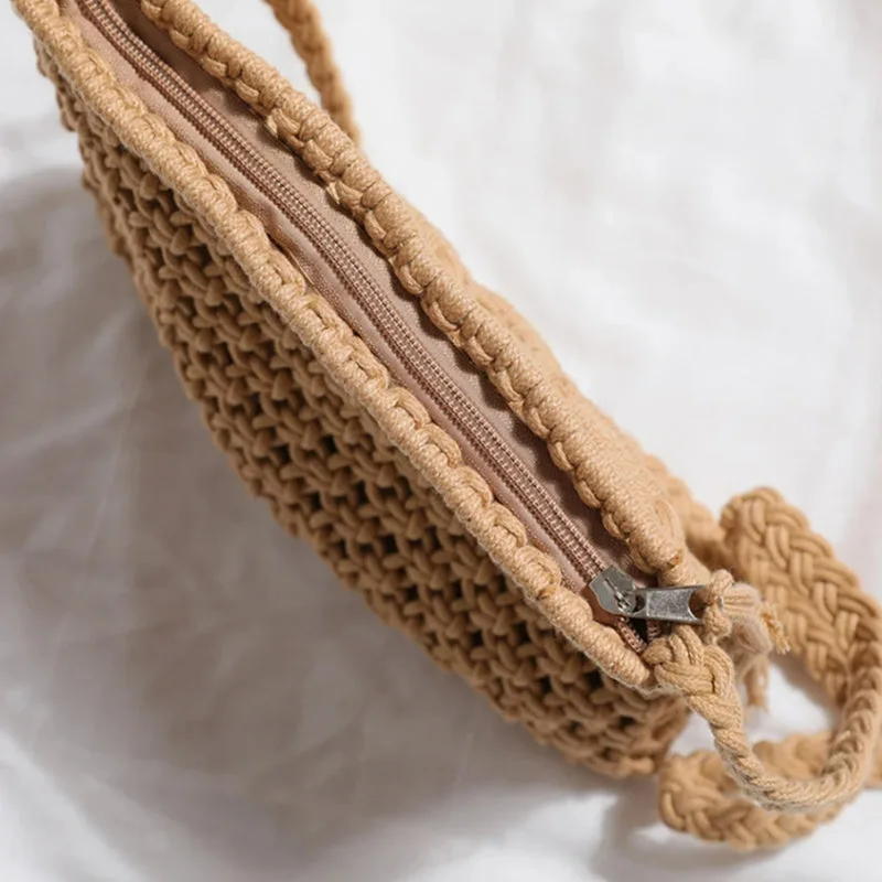Brun makramé clutch med dragkedja och detaljerad snördesign.