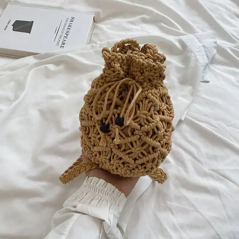 Brun makramé hinkväska i handen, hållbar och trendig axelväska för kvinnor.