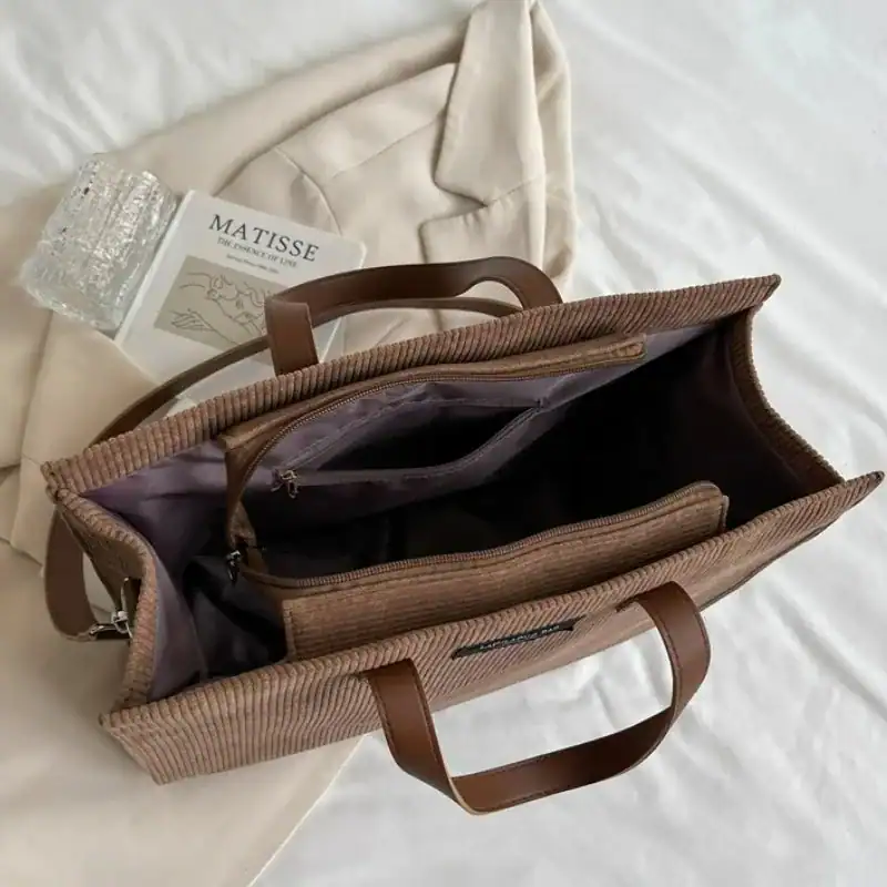 Brun Manchester shoppingväska med läderhandtag och inre fack.