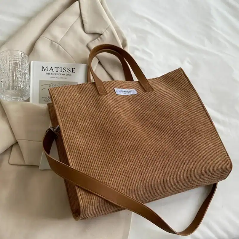 Brun corduroy shoppingväska med axelrem och handtag, passar till vardag och shopping.
