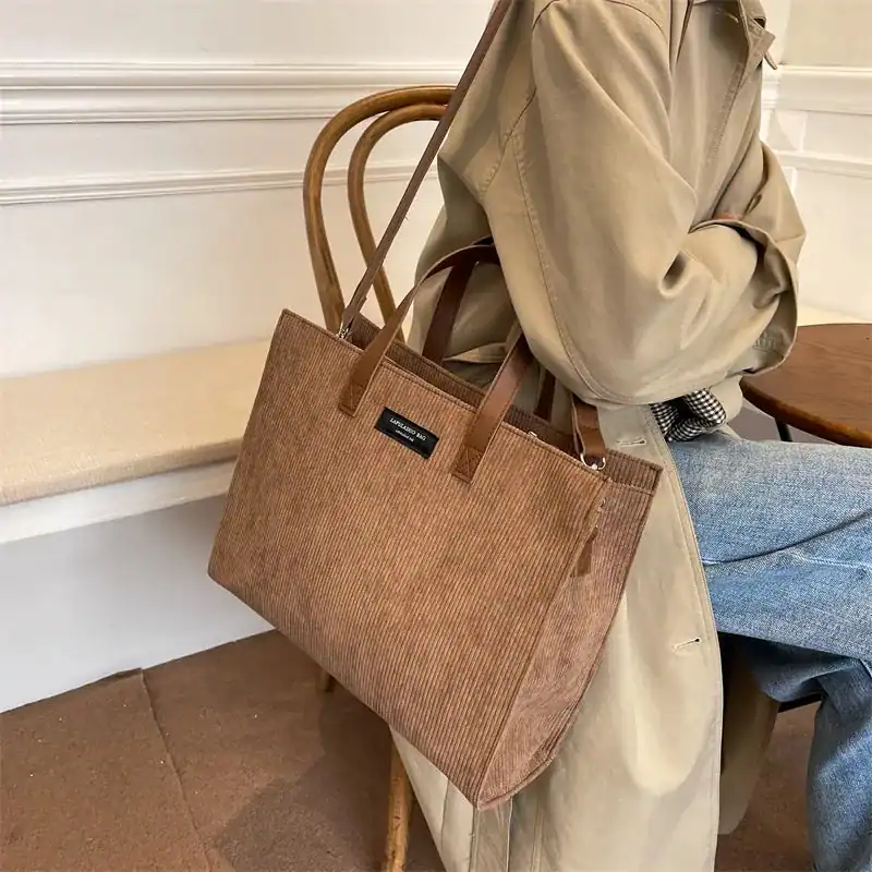Brun Manchester shoppingväska i corduroy med läderhandtag och plåtiknapp.