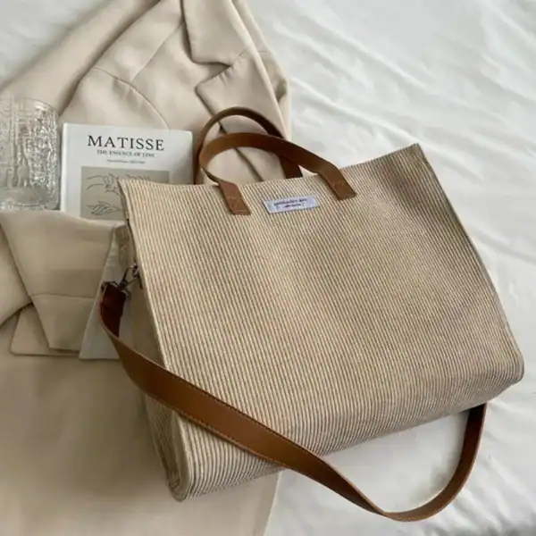 Brun Manchester shoppingväska i kanfas med läderhandtag och axelrem.