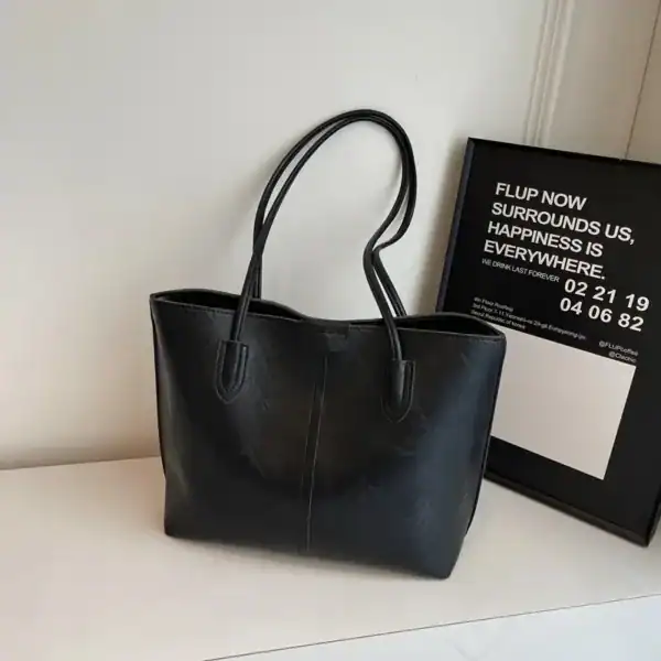 Brun shopper väska i svart läder, stor handväska med två handtag.