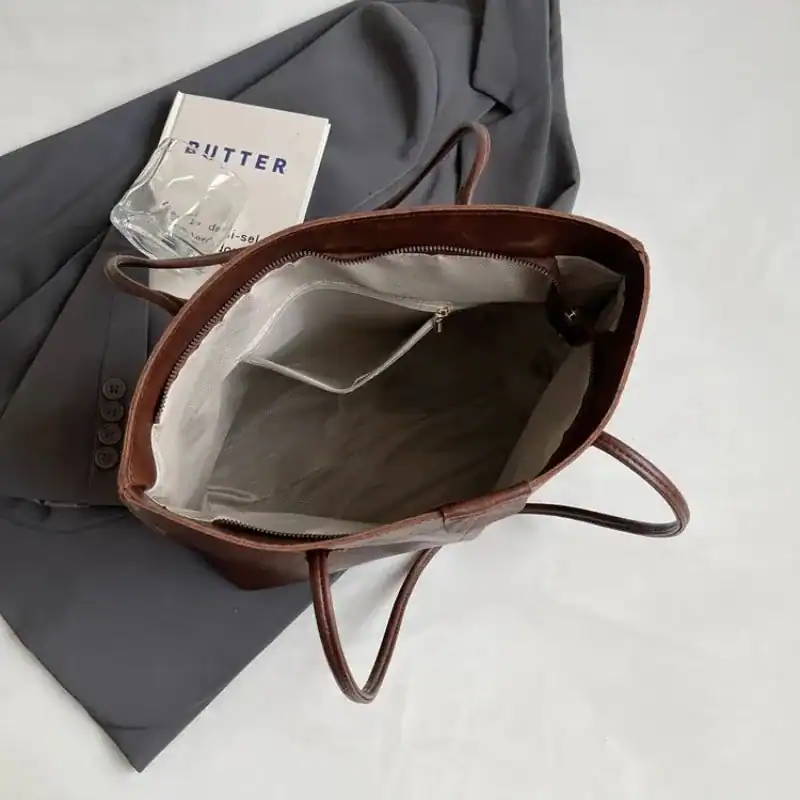Brun shopper väska med inre fickor och praktiskt inre, idealisk för vardag och arbete.