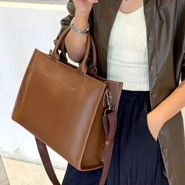 Brun shoppingväska med axelrem och handtag, lämplig för vardag och jobb.