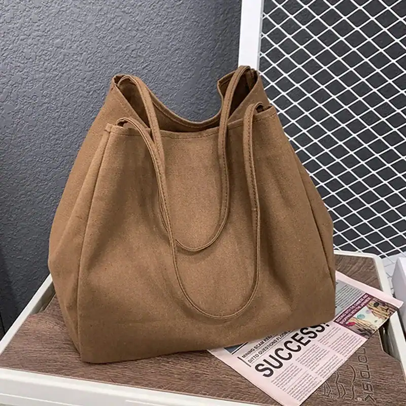 Brun tygshopper med långt handtag, stor kapacitet och stilrent design.