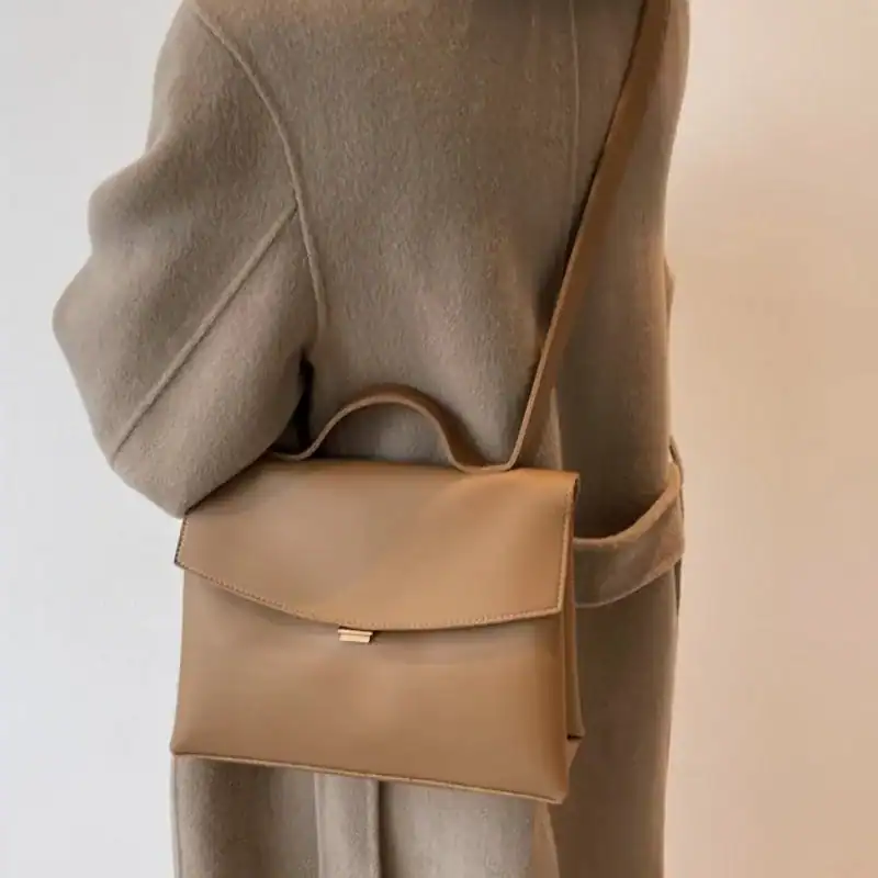 Brun Axelväska med handtag och axelrem, minimalistisk design för vardaglig användning.