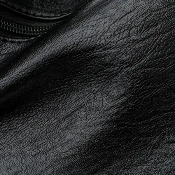 Brun väska med många fack, närbild på textil och dragkedja.