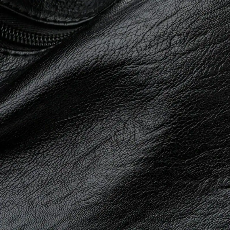 Brun väska med många fack, närbild på textil och dragkedja.
