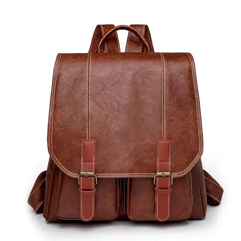 Brun vintage ryggsäck med läderliknande material och silverfärgade snäckor.