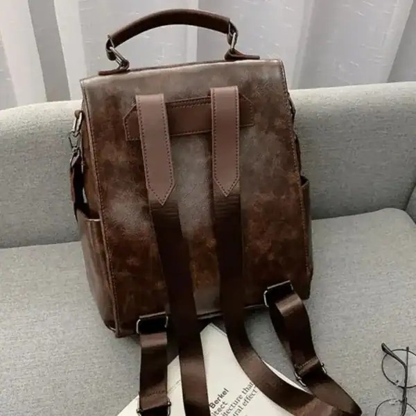 Brun vintage ryggsäck dam, retro design med axelremmar och handtag.