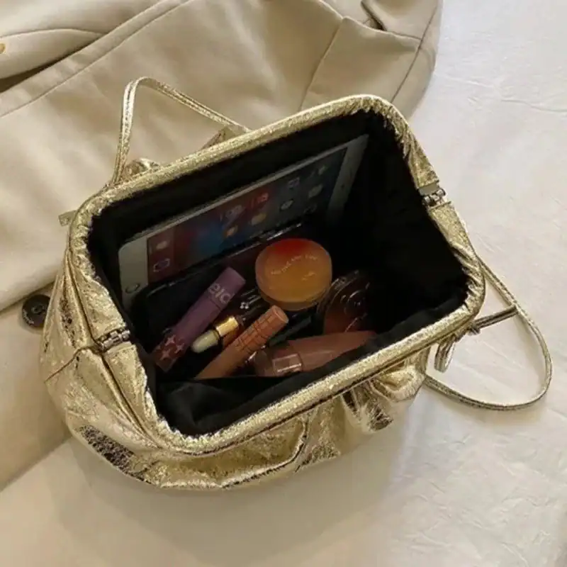 Guld clutch med innehåll, perfekt för kvällsutgång eller fest.