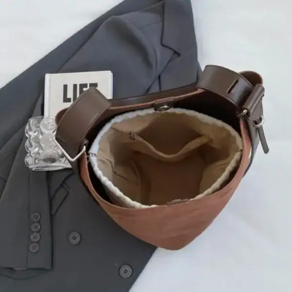 Cognac färgad hinkväska med inre ficka och läderrem, elegant axelväska för vardag.