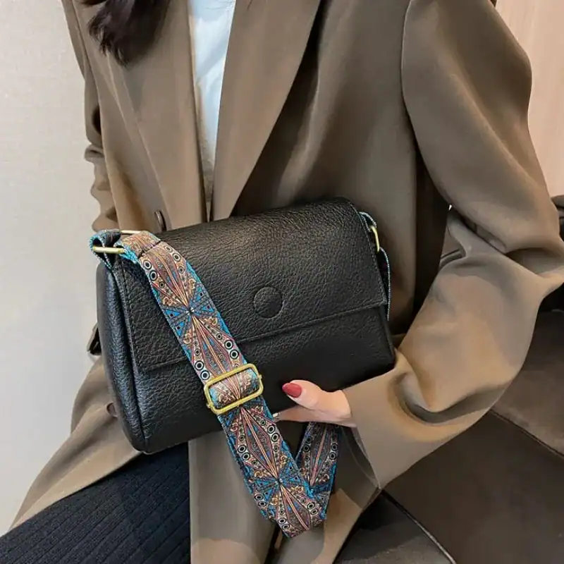 Cognac liten besväska med färgglad axelrem, svart läder, modeaccessoarer.