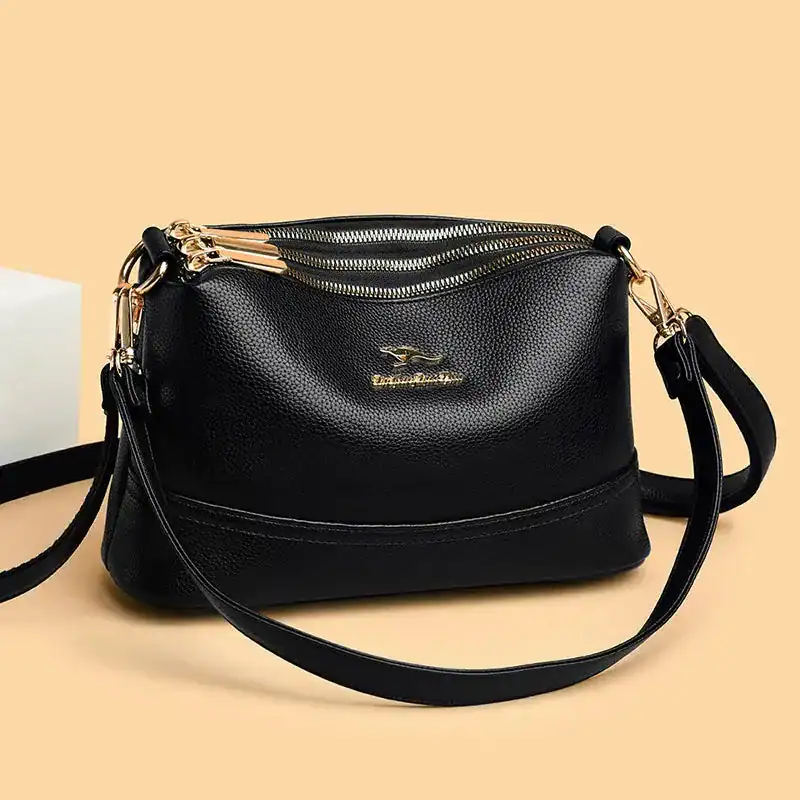 Svart läder crossbody väska med guld detaljer.