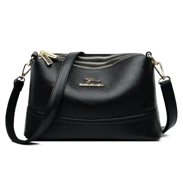 Svart läder crossbody väska med guld dragkedja och axelrem.
