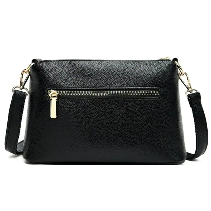 Svart cognac liten crossbody axelväska med guld dragkedja och axelrem.