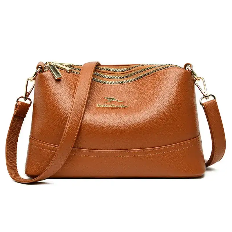 Cognac färgad liten crossbody axelväska med dragkedja och axelrem.