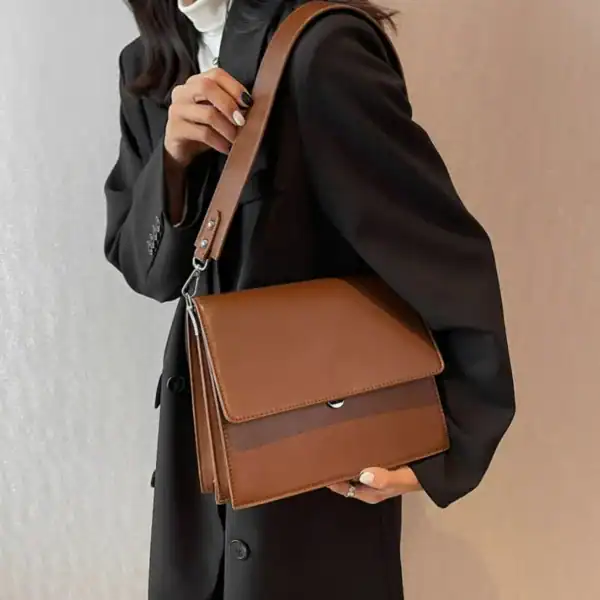 Cognac färgad axelväska med lock, läderliknande material och axelrem.