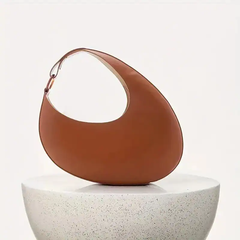 Cognacfärgad halvmånsväska i läder, modern design, axelväska för kvinnor.
