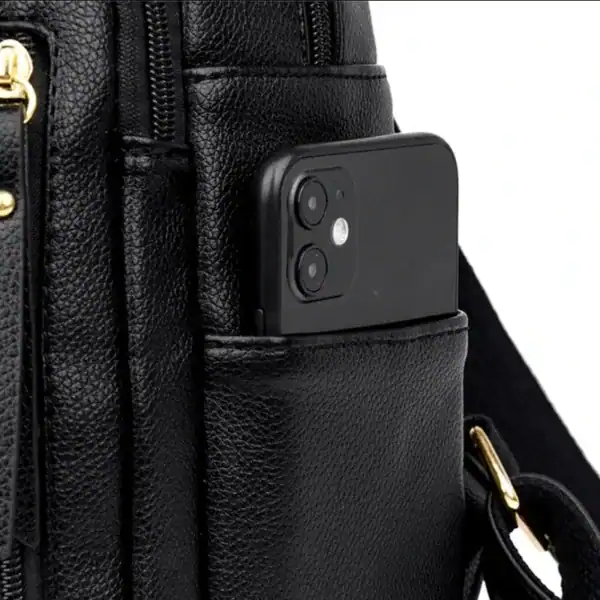 Svart ryggsäck med mobilfack, detalj på textil och metallkedja.