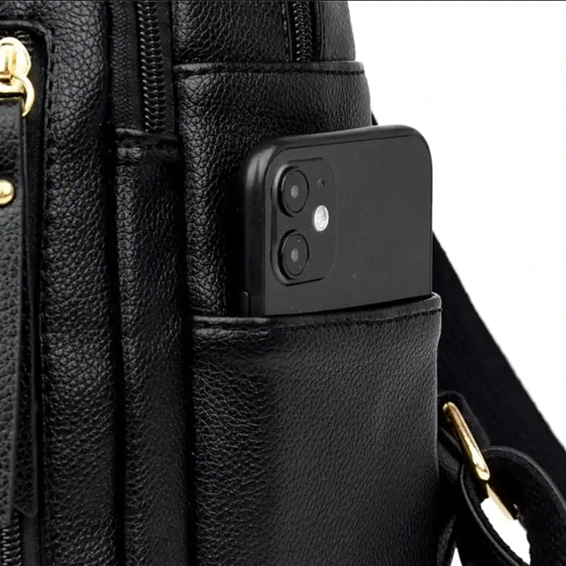 Svart ryggsäck med mobilfack, detalj på textil och metallkedja.