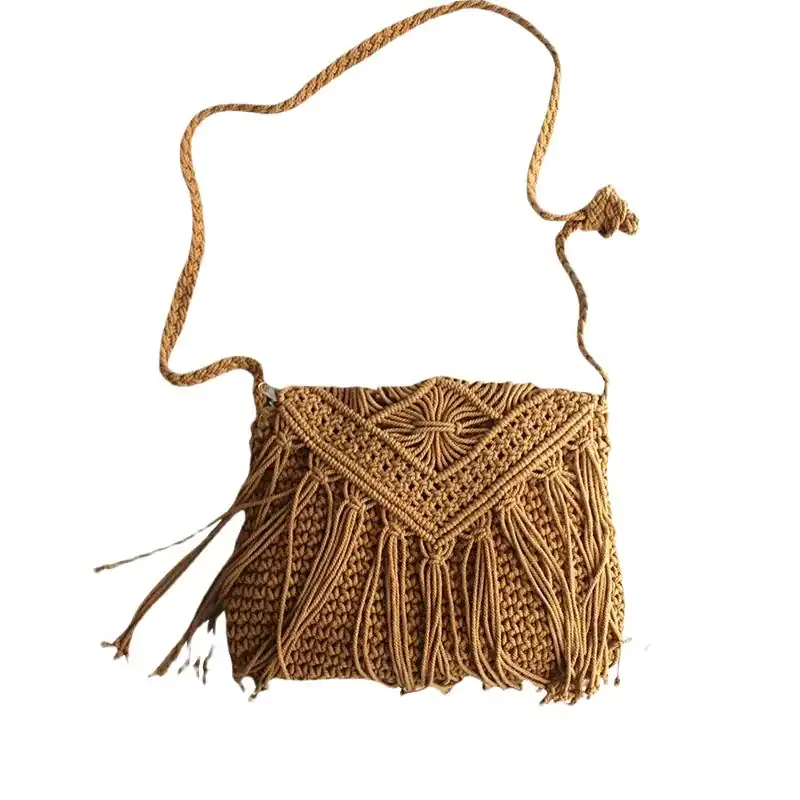Flätad handväska i naturfärgad macramé med fransar och axelrem.