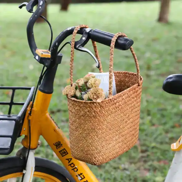 Beige flätad korgväska på cykel, ideal för daglig användning och utomhusaktiviteter.
