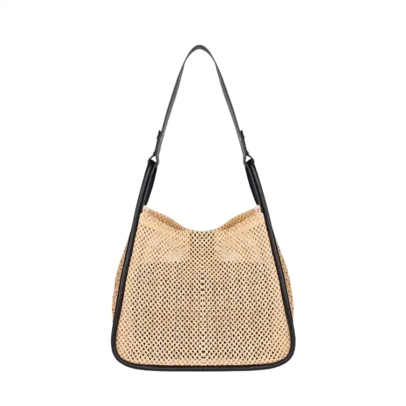 Beige flätad shoppingväska med svart läderrem och hängande design.