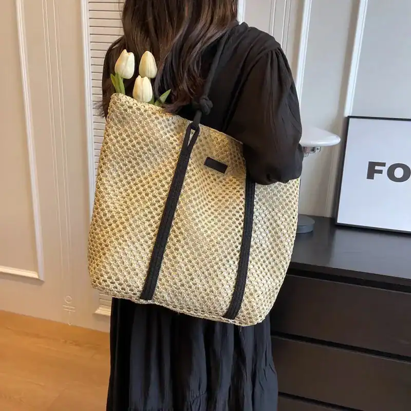Flätad shoppingväska med rem, lätt och stilfull för daglig användning.