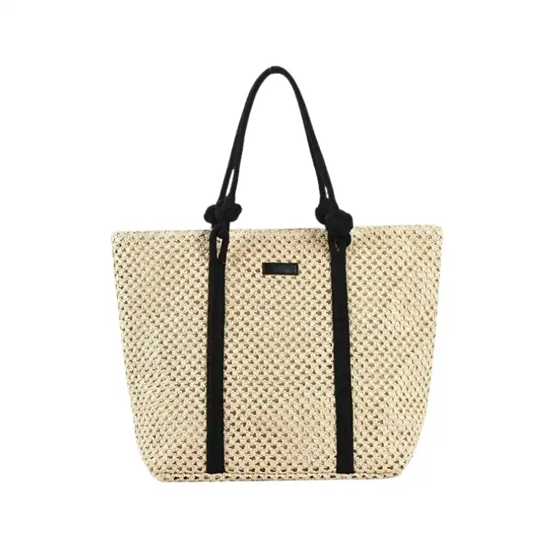Flätad shoppingväska med svart rem och praktiskt design.